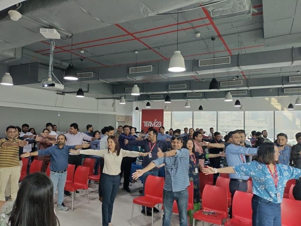Large group arm stretch exercise at corporate wellness programme